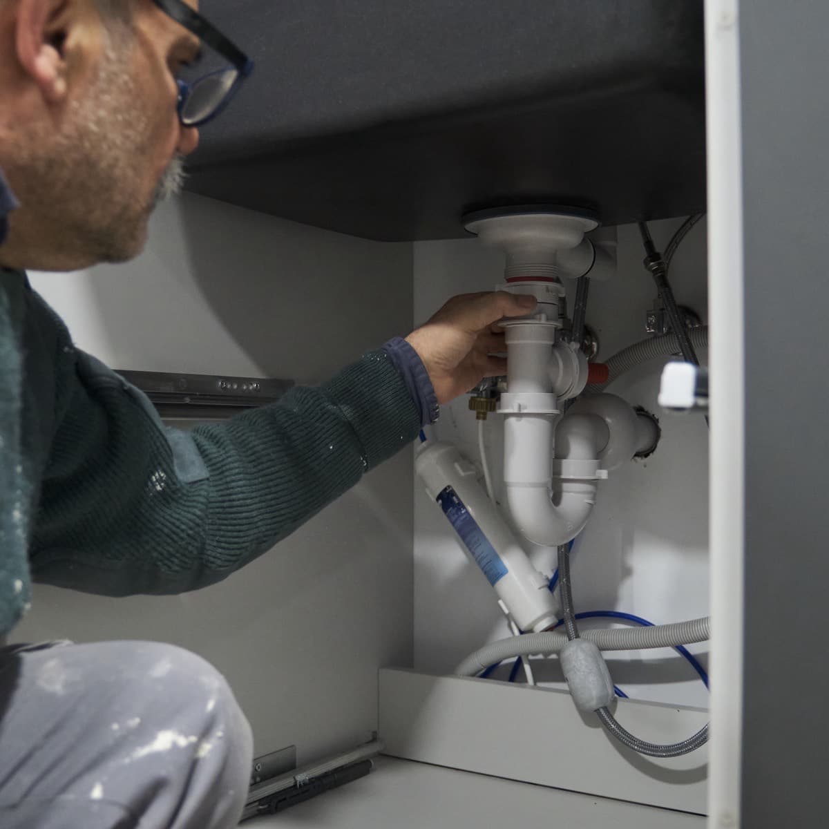 The kitchen sink trap, opened by hand during the visit to clear the blockage.